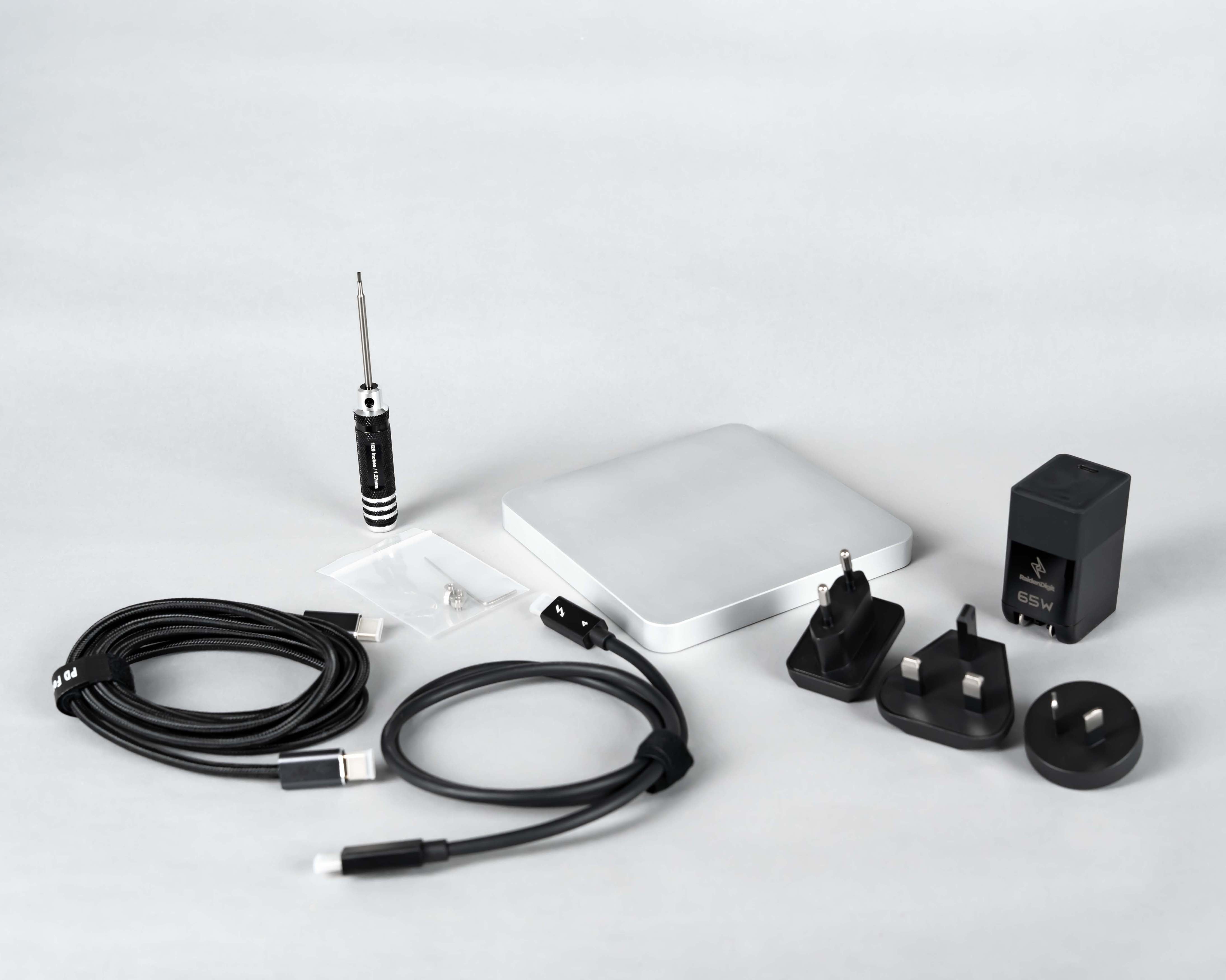 QuadDrive package contents laid out with the enclosure, cable, power parts, tools, screws, and guide